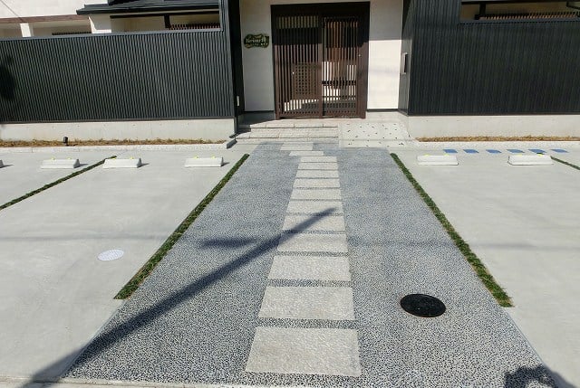 駐車場　駐車面はコンクリート仕上（見切りを入れて区画）、メインアプローチは割石敷き+豆砂利洗出し仕上げ